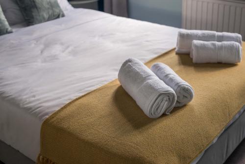 a bed with two rolled up towels on it at Charis Guesthouse in Makrinítsa