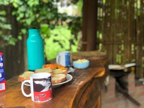 a table with a plate of food and a cup of coffee at Casinha Azul de Penedo in Penedo