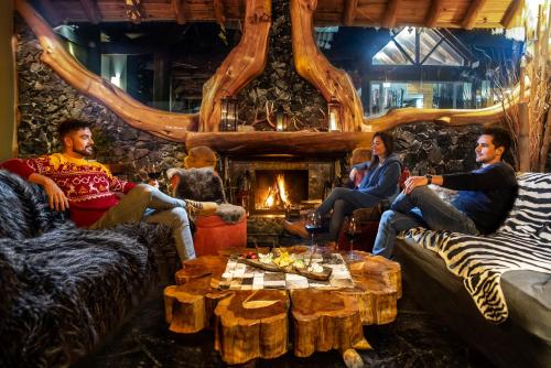 a group of people sitting in a room with a fireplace at Hosteria Sudbruck in San Carlos de Bariloche