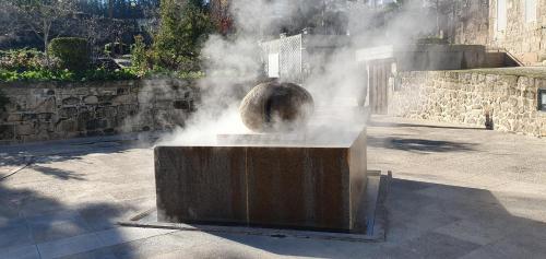 a fountain with steam coming out of a statue at Casa Salomão in Termas de Sao Pedro do Sul