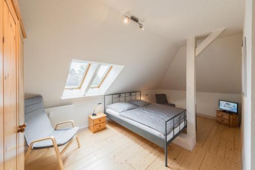 - une chambre avec un lit et une chaise dans l'établissement Villa Brodthage, App. 1, à Walkenried