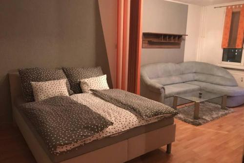 ein Schlafzimmer mit einem Bett, einem Sofa und einem Stuhl in der Unterkunft Apartman QUATTRO in Sokolov