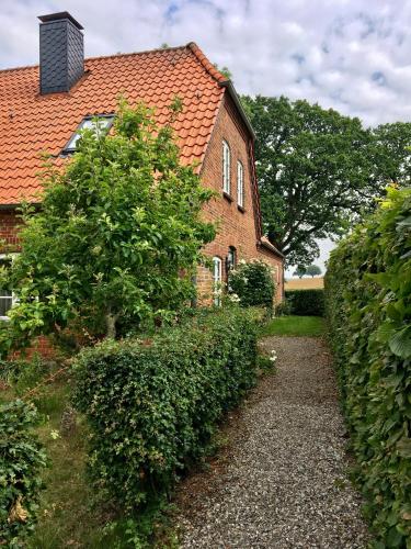 a brick house with an orange roof at Gutshof Rothensande in Waabs