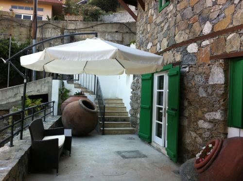 a white umbrella sitting next to a building at Maison Elena in Kalopanayiotis