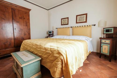 a bedroom with a large bed and a wooden cabinet at Borgo Grondaie in Siena