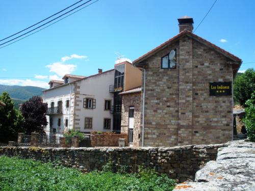 a stone house with a stone wall in front of it at Alojamiento rural Las Indianas in Villar