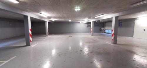 an empty parking garage with white floors and red and white columns at Hotel CityMap Maribor in Maribor