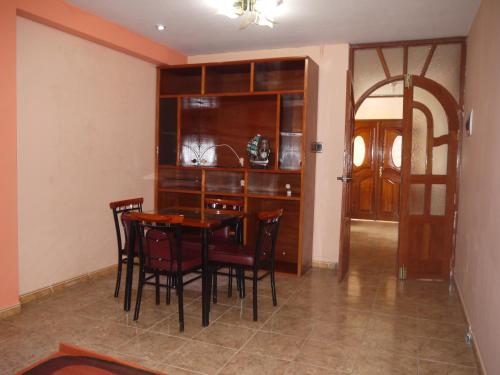 een eetkamer met een tafel en stoelen en een keuken bij Hotel Suite Juliaca in Juliaca