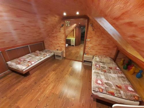 Zimmer im Dachgeschoss mit 2 Betten und einem Spiegel in der Unterkunft Rodinný dom Petro s Wallbox nabíjaním elektromobilu in Rabča