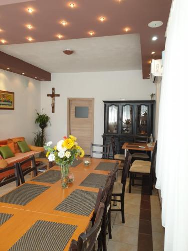 a dining room with a long table with flowers on it at Sobe BCRNJAC in Međugorje