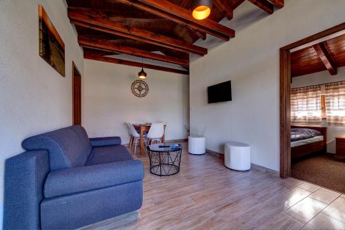 a living room with a blue couch and a table at Apartment Lazoň in Pavčina Lehota