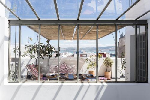 a glass room with a view of a city at Riad Dar-tus in Tangier