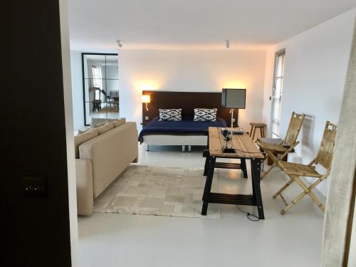 a living room with a bed and a table and chairs at Galerie, Tumulus de la Hogue in Fontenay-le-Marmion