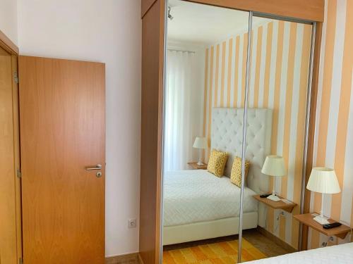 a bedroom with a bed and a glass door at Duarte Houses T2 - com vista mar in Nazaré