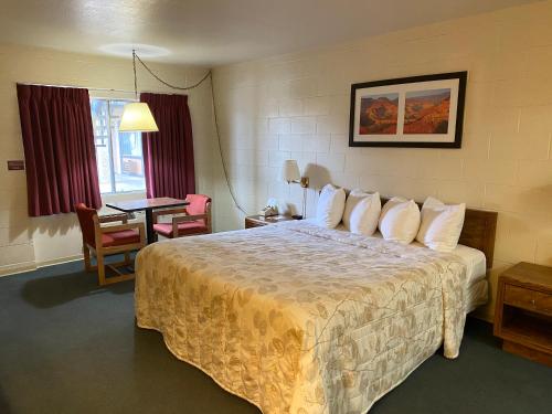 a hotel room with a bed and a table at Orland Inn in Orland