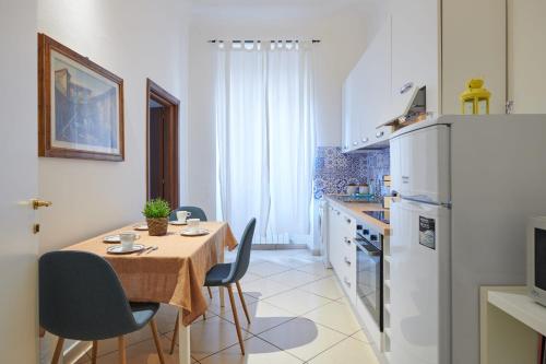 a kitchen with a table and chairs and a kitchen with white appliances at Florence&Us Santa Croce in Florence
