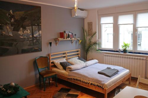 Schlafzimmer mit einem Bett, einem Tisch und Stühlen in der Unterkunft Atelier 22 in Belgrad