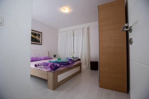 um quarto com uma cama com almofadas roxas em Apartment Mattias free private parking em Mostar