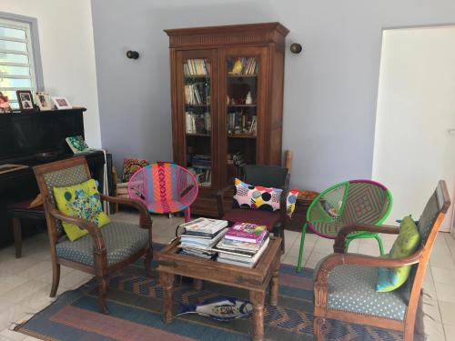 a living room with chairs and a coffee table at Jardin des Anges-Bungalows créoles et studio in Le Moule
