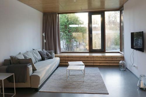 a living room with a couch and a large window at Design Ferienhaus nienrausch mit 2 Apartments in Timmendorfer Strand