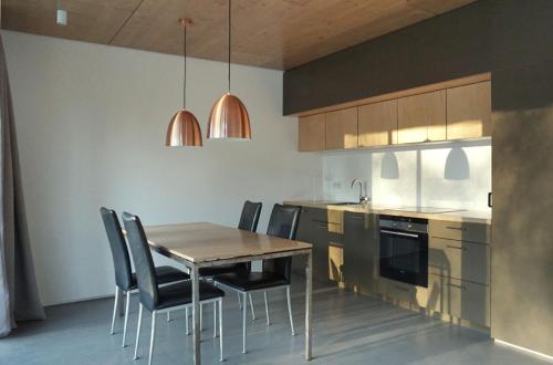 een keuken met een tafel en stoelen bij Design Ferienhaus nienrausch mit 2 Apartments in Timmendorfer Strand