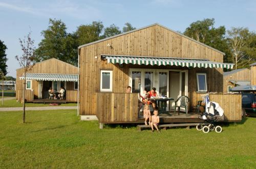 a wooden house with people standing outside of it at Camp Hverringe in Dalby