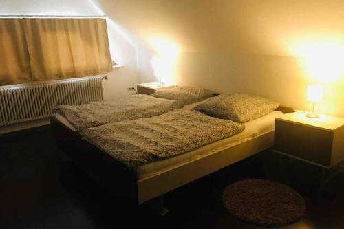 a bedroom with two beds and a window and two lamps at Monte Kali in Mittelkalbach