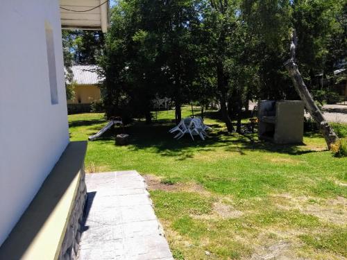 un patio con una mesa de picnic en el césped en Cabaña Sol del Bayo en Villa La Angostura