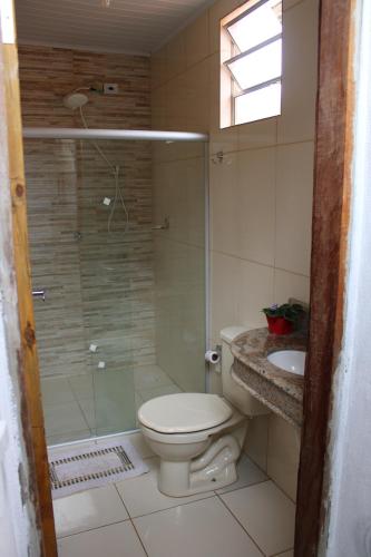 a bathroom with a shower and a toilet and a sink at Casa Cheia de charme in Mucugê