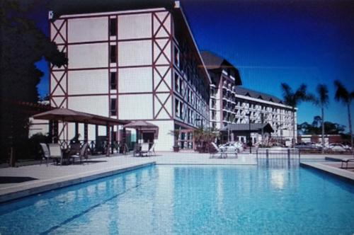 une grande piscine en face d'un bâtiment dans l'établissement Apart Hotel Pedra Azul, à Pedra Azul
