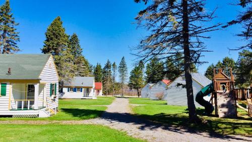a yard with houses and a tree at Green Gables Bungalow Court in Cavendish