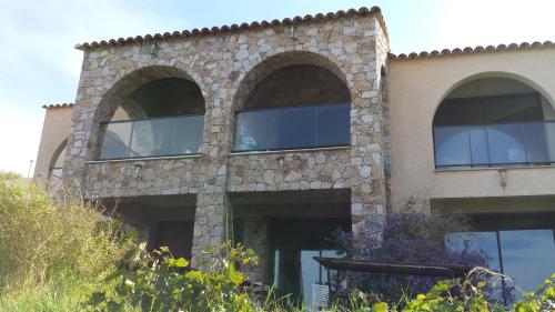 a stone building with three arched windows on it at Castelia in Lumio