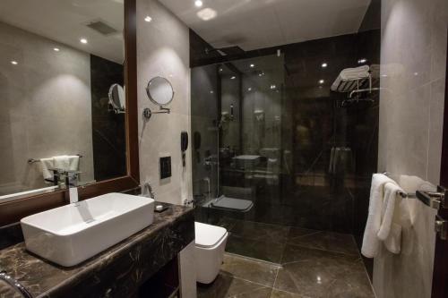 a bathroom with a sink and a shower and a toilet at mawasim al hay at hotel in Jeddah