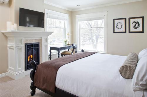 ein Schlafzimmer mit einem Bett und einem Kamin in der Unterkunft Edwards House in Fort Collins