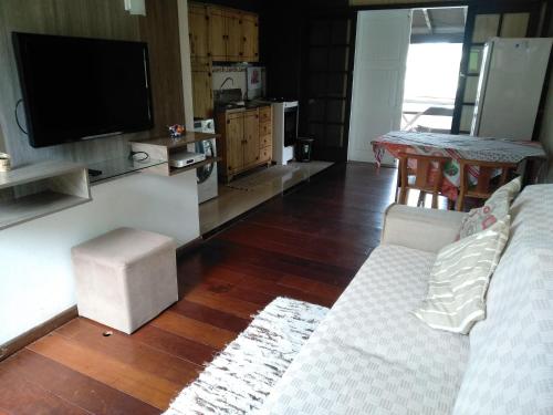 a living room with a couch and a flat screen tv at Casa a 50 mt da Praia. in Bombinhas