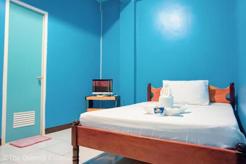 a blue bedroom with a bed and a television at King Michael Coron in Coron