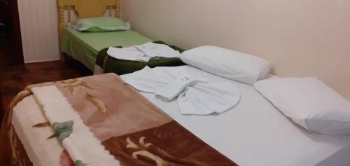 a bed with clothes on top of it in a room at Hotel Do Oeste in Palmitos