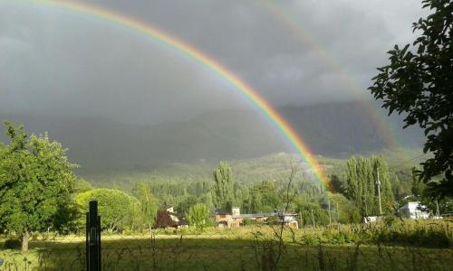 un arco iris sobre un campo con en Casa Sur, en El Bolsón