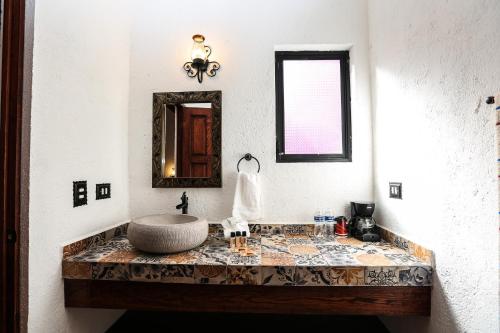 La salle de bains est pourvue d'un lavabo et d'un miroir. dans l'établissement El mesón del Quijote, à San Miguel de Allende