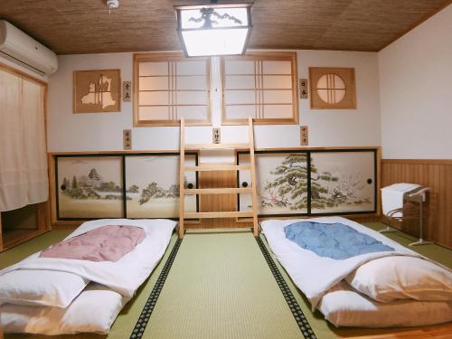 two beds in the middle of a room at PittINN in Goshogawara