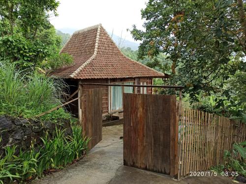 a small house with a gate and a fence at DWan Tea Mountain Side in Jatiluwih