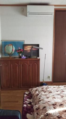 a bedroom with a bed and a large wooden cabinet at 町中ステイ 宗ハウス in Nachikatsuura