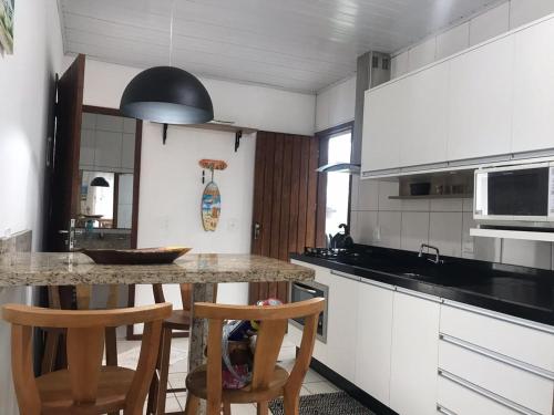 una cocina con mesa y 2 sillas. en Residencial la bela praia, en Florianópolis