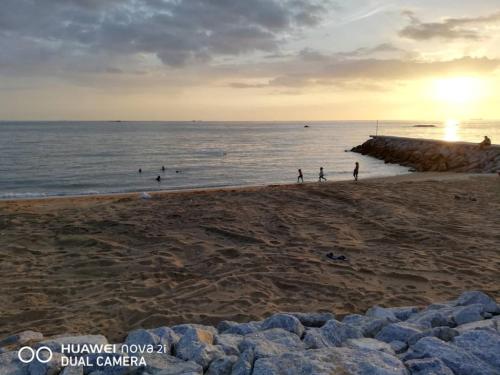 a group of people on the beach at sunset at Mutiara Chalet in Melaka