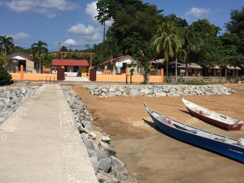 two boats sitting on the shore of a beach at Mutiara Chalet in Melaka