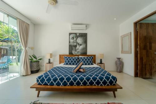 a bedroom with a bed with a blue comforter at Villa Saffira in Seminyak