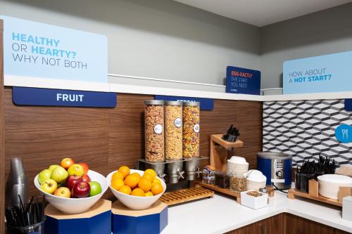 大草原城大草原智选假日酒店的一家商店的柜台上摆放着几碗水果和蔬菜。