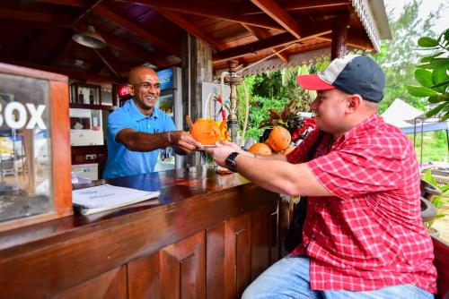 a man sitting at a bar making a drink at Peacock Beach Hotel Unawatuna in Unawatuna