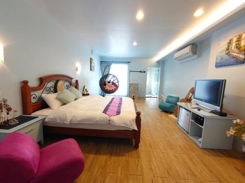 a bedroom with a large bed and a television at Lotus Hostel Beicheng Zhuang in Luodong