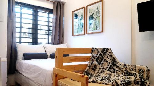 1 dormitorio con 1 cama, 1 silla y 1 ventana en Mireya's Studio Condo at Goshen Towers - Session Road, en Baguio